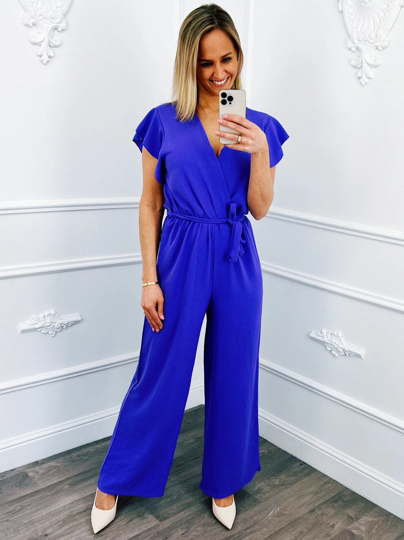 https://blushfashionstore.nl/collections/blouses/products/ruffel-jumpsuit-lila?%3Fvariant%3D=45559410065700